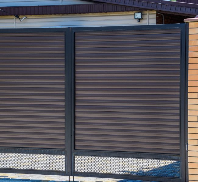 Gates of brown metal sheets. Roofing materials. Modern types of roofing materials.